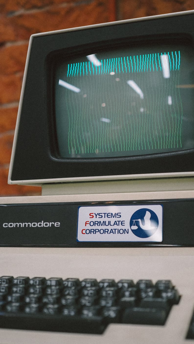 A vintage Commodore computer terminal with a glowing green screen
